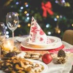 Christmas Parties: HMRC and Tax 5 A Christmas table setting with a Christmas tree in the background, perfect for festive parties.