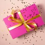 Employee Gifts and Trivial Benefits 6 A pink gift box with gold confetti, perfect for Employee Gifts.