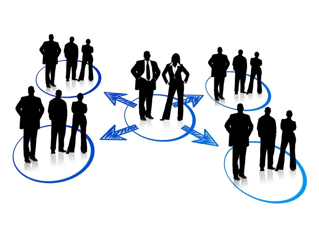 A group of people standing around a circle, involved in a partnership or limited company formation, discussing potential tax changes.