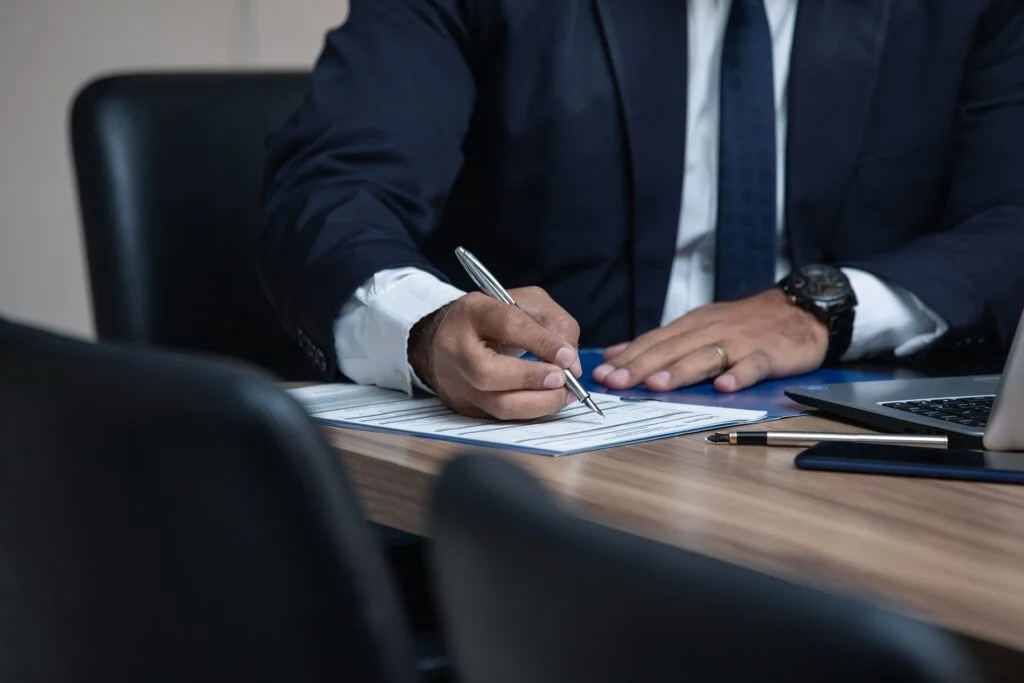 A businessman signing a document for inheritance tax planning at a desk.