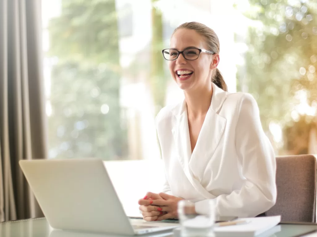 Business woman smiling at laptop