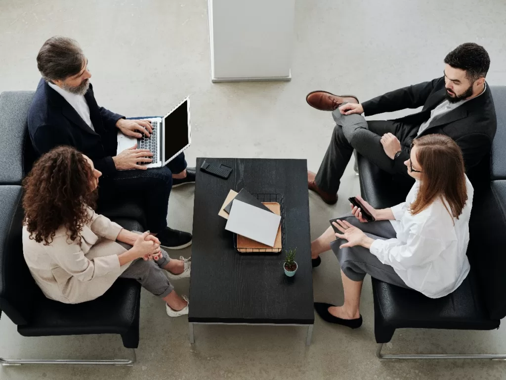 Business meeting with four people and laptop
