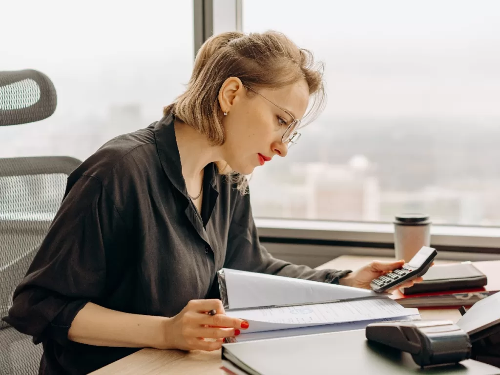 Self-Assessment Payments on Account 1 Woman at desk reading notes holding a calculator