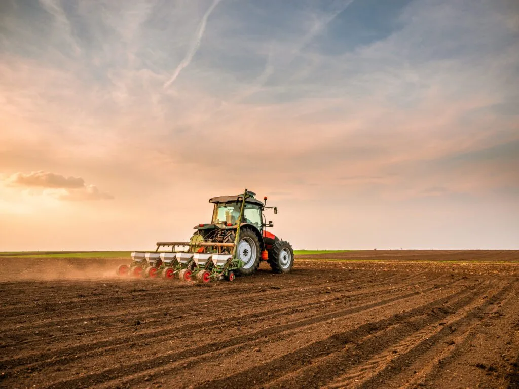March 2026 Newsletter 5 Tractor ploughing field at sunset.