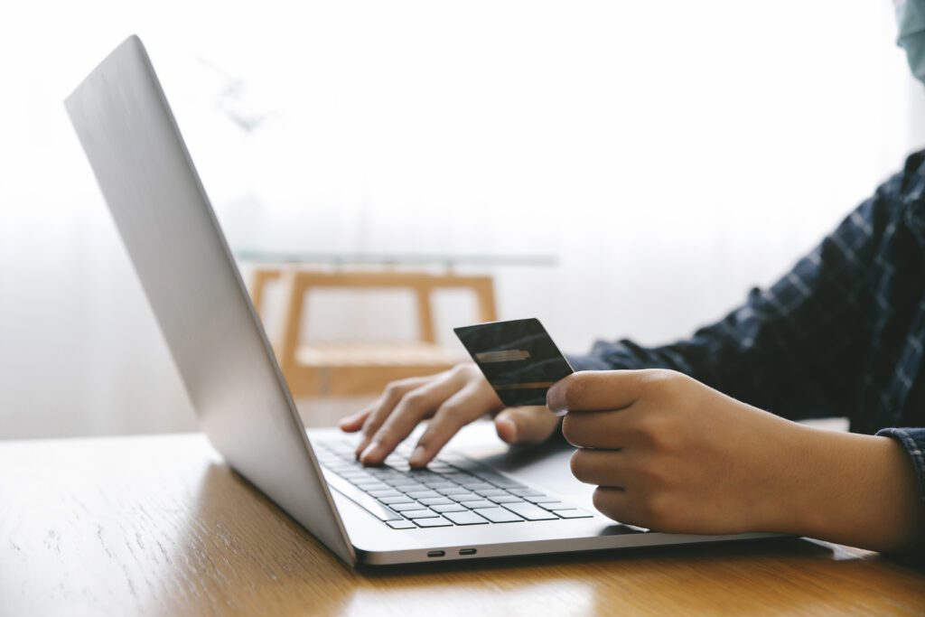 August 2026 Newsletter 4 Man Holding credit card and using a laptop