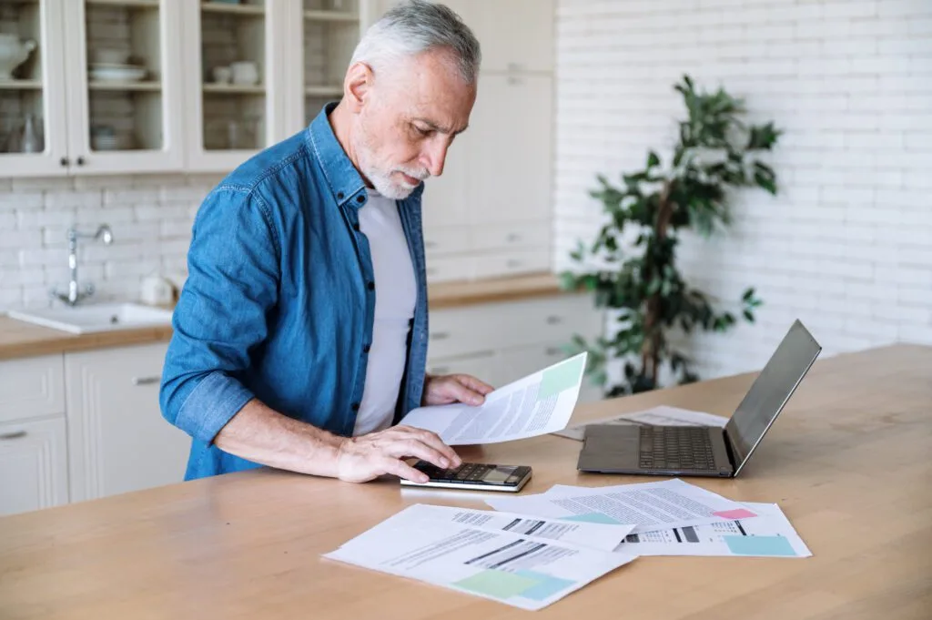 Man working with documents and laptop.