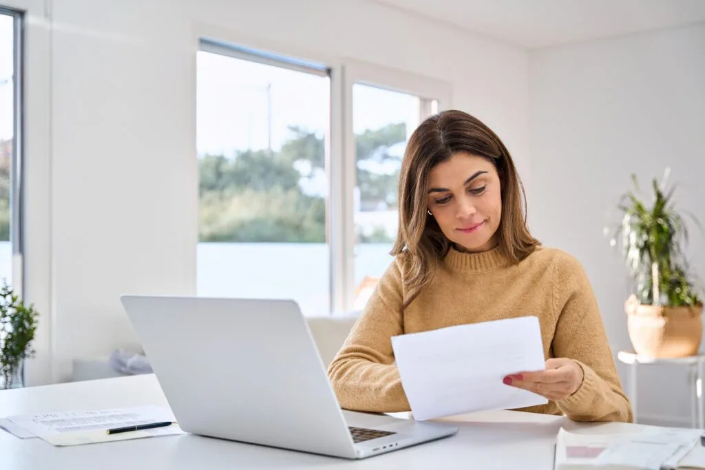Person reading documents at desk.
