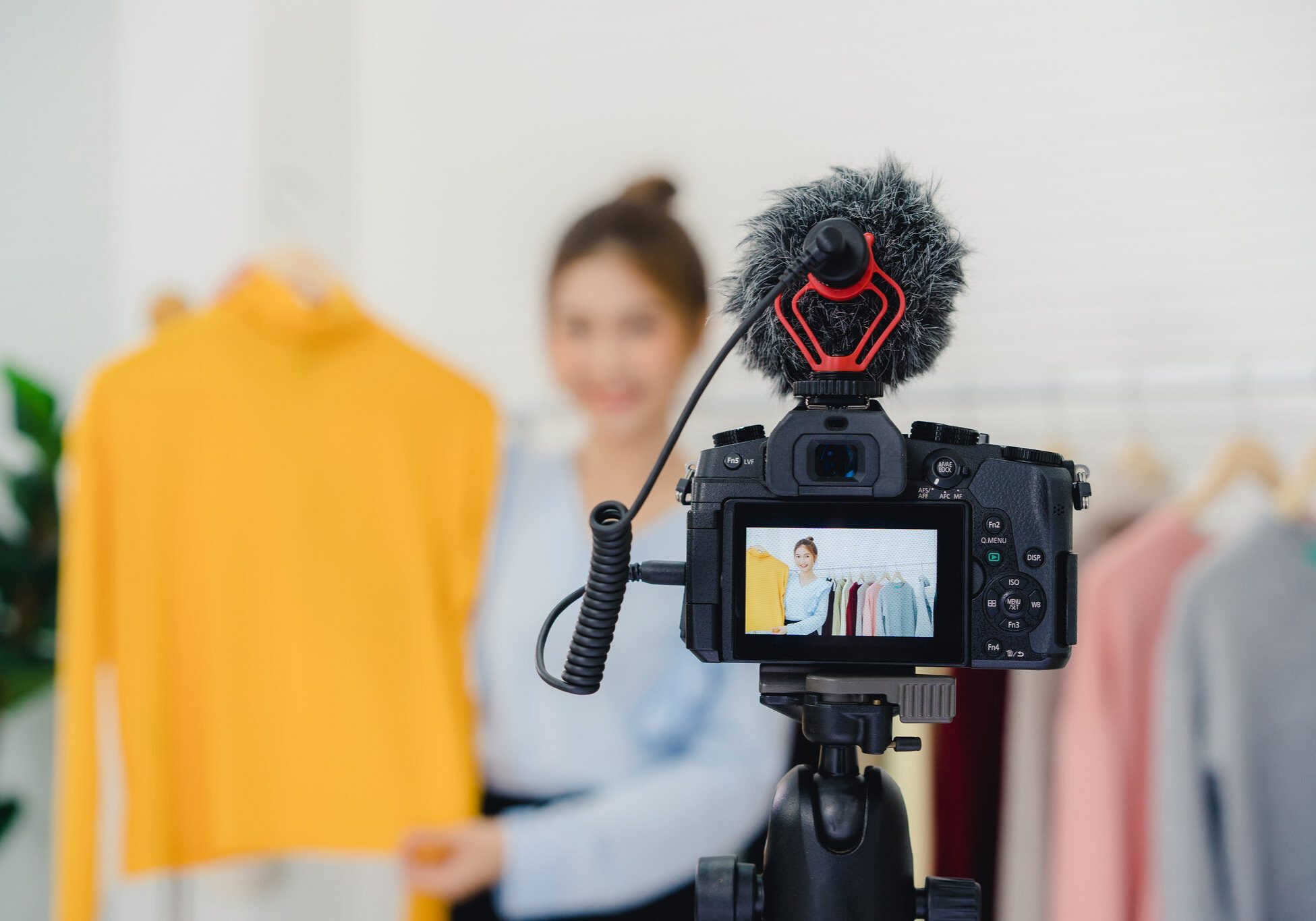 A social influencer is filming a video in a clothing store.