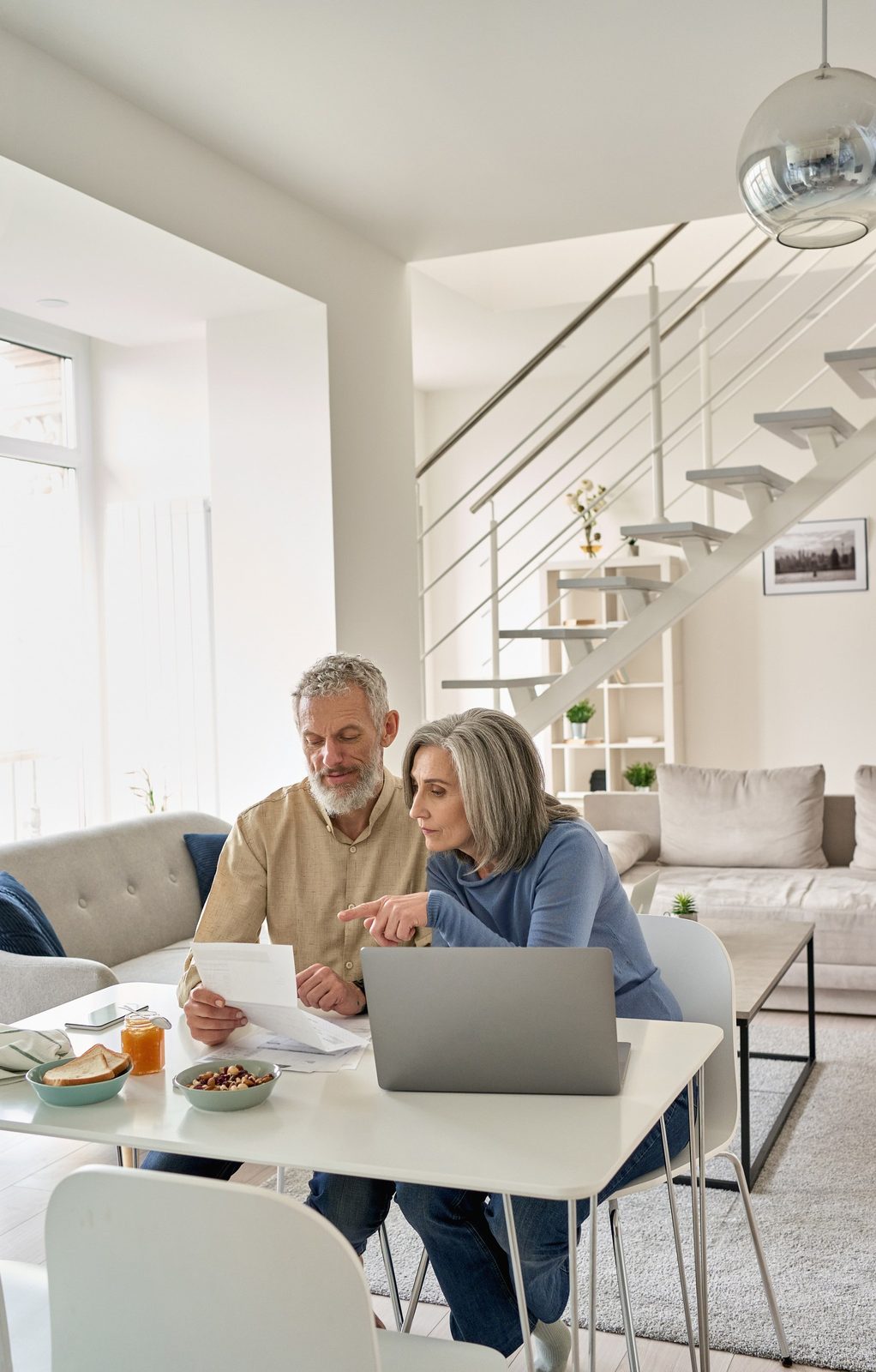Pension Estate Report 1 Senior couple checking documents on a laptop at home